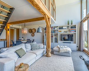 Villa 193, De Koog, Texel, spacious living room with comfortable sofa and large windows for lots of natural light.