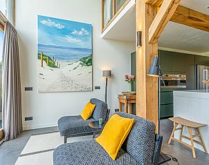 Stylish sitting area in Villa 193, De Koog, Texel, with painting and modern furniture in a bright space.