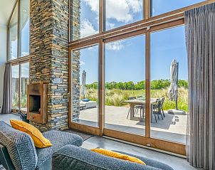 Large windows and terrace view in Villa 193, De Koog, Texel, vacation home with lots of natural light.