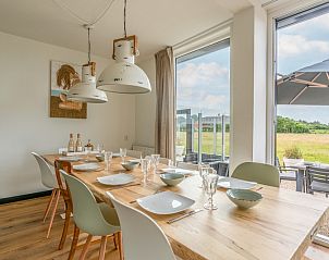 Dining room of Orchismient 17 vacation home in De Koog Texel with large table and garden view.