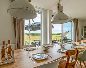 Cozy dining area of Orchismient 17 in De Koog Texel overlooking the Texel landscape.