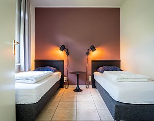 Zweites Schlafzimmer von Bungalow 19A in De Koog, Texel mit zwei Einzelbetten und warmer Einrichtung.