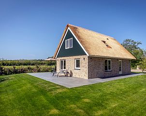 Seitenansicht von Landhuis De Wije Blick, Ferienhaus in De Koog, Texel, mit sonnigem Garten und Terrasse.