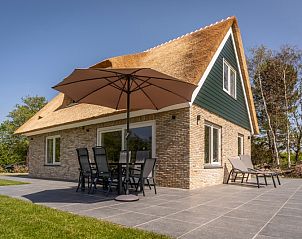 Terrasse von Landhuis De Wije Blick in De Koog, Texel, Ferienhaus mit Sonnenschirm und Gartenmbeln.