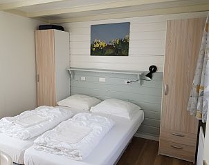 Bedroom in Bungalow 5100, Texel, with double bed and painting.