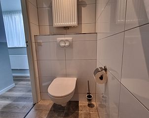 Tight bathroom in Bungalow 5100, De Koog, Texel with toilet and tiles.