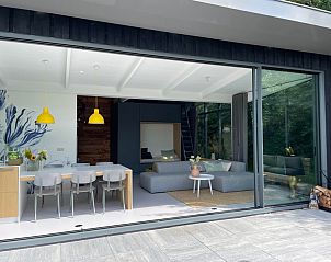 Modern dining room in De Koerie vacation home De Koog Texel with stylish decor and views of nature.