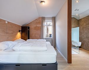 Gerumiges Schlafzimmer des Ferienhauses Pippa, De Koog, Texel, mit angrenzendem modernen Badezimmer.