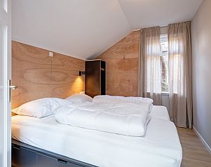 Gemtliches Schlafzimmer im Ferienhaus Pippa auf Texel mit Holzakzenten und viel Tageslicht.