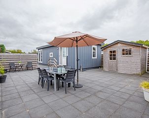 Spacious terrace at Chalet Bregkoog 261, Chaletpark Bregkoog, De Koog, Texel. Outdoor furniture and parasol for summer days.