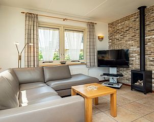 Gemtliches Wohnzimmer der Villa mit Wintergarten in De Koog, Texel, mit Kamin und gemtlicher Sitzecke.