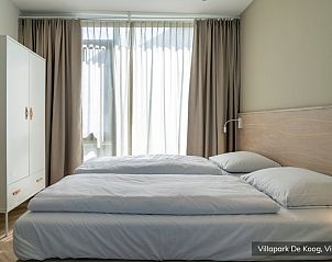 Gezellige slaapkamer in Luxe familievilla 4p, De Koog, Texel met grote ramen en veel natuurlijk licht.