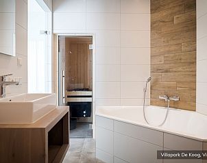 Moderne badkamer met bad en sauna in Luxe familievilla 4p, De Koog, Texel voor ultieme ontspanning.