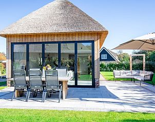 Veranda of Villa Jolie in De Koog, Texel, Wadden Islands, with comfortable seating and garden views.