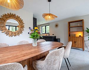 Cozy dining area in Villa Jolie, De Koog, Texel, with wooden table and stylish lighting.