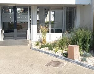 Eingang zu De Pelikaan Apartments, De Koog, Texel, umgeben von Grnpflanzen und einem einladenden Eingang.