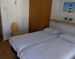 Komfortables Schlafzimmer in De Pelikaan Apartments, De Koog, Texel mit zwei Betten und ruhiger Einrichtung.