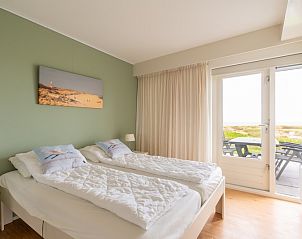 Bedroom with access to the terrace and views of nature in Apartment Juliana 066 Zeezicht, Texel.