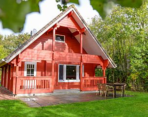 Charmantes Ferienhaus mit roter Fassade im Ferienpark Het Oude Dijkje, De Koog, Texel, umgeben von viel Grn.