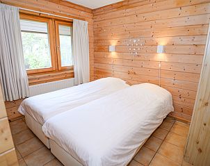Schlafzimmer mit zwei Betten und Holzwnden im Vakantiepark Het Oude Dijkje, De Koog, Texel, bietet Ruhe und Komfort.