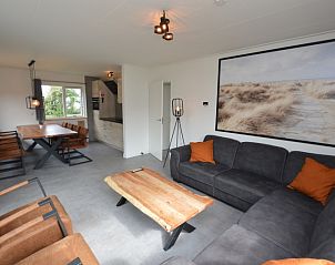 Innenraum des Ferienhauses Stappeland 203 in De Koog Texel, mit gemtlicher Sitzecke und Kunst an der Wand.