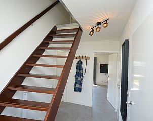 Eingang zum Ferienhaus Stappeland 203 in De Koog Texel, mit Holztreppe und moderner Beleuchtung.