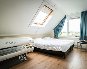 Bright bedroom with a double bed in Villa 6 persons, De Koog, Texel. View of the nature of the Wadden Islands.