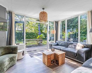 Bright living room of Bungalow De Nagtegaal 21 in De Koog Texel, with comfortable seating area and garden views.