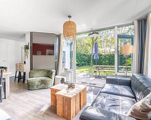 Open living room of Bungalow De Nagtegaal 21 in De Koog Texel, with access to the terrace and lots of natural light.