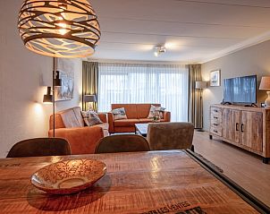 Esszimmer und Wohnzimmer in Appartements Anna - Dageraad, De Koog, Texel mit stimmungsvoller Beleuchtung und Holztisch.