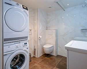 Attraktives Schlafzimmer in Apartments Anna - Dageraad, De Koog, Texel mit zwei bequemen Betten und farbenfroher Kunst.