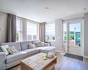 Cozy living room in Apartment Juliana 034 Eilandzicht, De Koog, Texel with comfortable sofa and garden view.