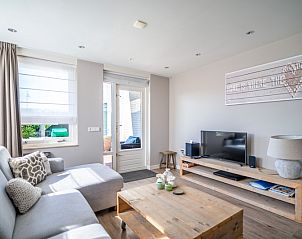 Stylish living room in Apartment Juliana 034 Eilandzicht, De Koog, Texel with flat-screen TV and access to outdoor space.