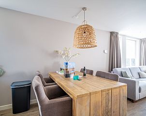 Dining area with wooden table in Apartment Juliana 034 Eilandzicht, De Koog, Texel for cozy dinners.
