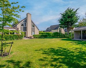 Vacation home Honeysuckle 93 with sauna in De Koog, Texel, surrounded by green garden and terrace.