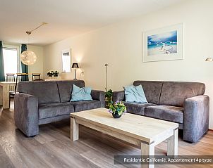 Gemtliches Wohnzimmer im Ferienhaus Typ 5A, De Koog, Texel, mit bequemen Sofas und dekorativen Kunstwerken.