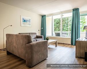 Helles Wohnzimmer in einer Unterkunft vom Typ 5A, De Koog, Texel, mit groem Fenster und Blick auf die Natur.