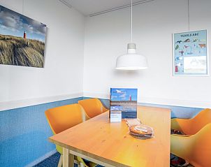Dining area with colorful chairs in Apartment Juliana 068 Island and Sea View, De Koog, Texel.