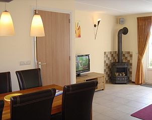 Dining room with wood stove in 6-person vacation home with sauna, De Koog, Texel
