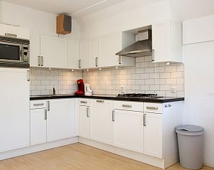 Moderne keuken in bungalow T8A, De Koog, Texel. Stijlvolle binnenruimte met witte kasten en moderne apparatuur voor een comfortabel verblijf.