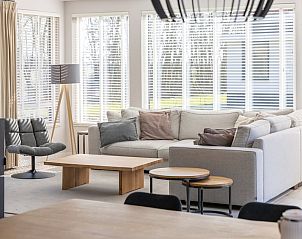 Stylish living room in Villa 8, a vacation home in De Koog, Texel, with comfortable seating area and lots of natural light.