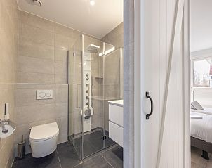 Modern bathroom in Villa 8, a vacation home in De Koog, Texel. Luxurious interior with bathtub and double sink for ultimate comfort.