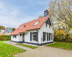 Bungalow T6A in De Koog, Texel, met rieten dak en zonnig terras, omgeven door groene natuur op de Waddeneilanden.