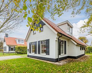 Geniet van het terras bij bungalow T6A in De Koog, Texel, omgeven door herfstbladeren en groene natuur op de Waddeneilanden.
