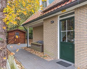 T6B bungalow in De Koog, Texel met charmante veranda en herfstbladeren, ideaal voor een rustige vakantie op de Waddeneilanden.