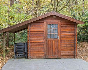 Houten bijgebouw bij bungalow T6B in De Koog, Texel. Rustieke uitstraling omringd door natuur op de Waddeneilanden.