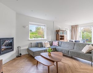 Spacious living room in Stappeland 197, vacation home De Koog, Texel with corner sofa and garden view.