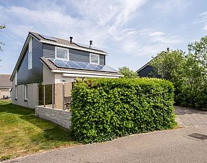 Ferienhaus Stappeland 169 in De Koog Texel mit grnem Zaun und Sonnenkollektoren.
