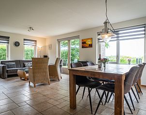 Spacious living room of Villa 304 in De Koog, Texel with comfortable seating area and garden view.