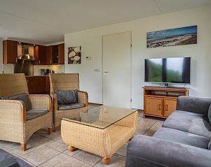 Cozy sitting area in Villa 304, De Koog, Texel with modern furnishings and television for relaxation.